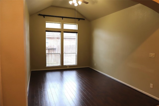 empty room with vaulted ceiling, dark wood-type flooring, a ceiling fan, and baseboards