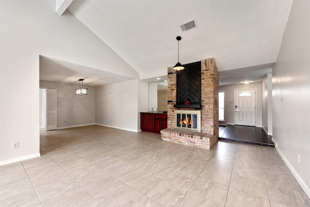 living area featuring high vaulted ceiling, visible vents, a fireplace, and baseboards