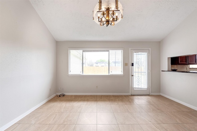 interior space featuring a chandelier, a textured ceiling, baseboards, and light tile patterned floors