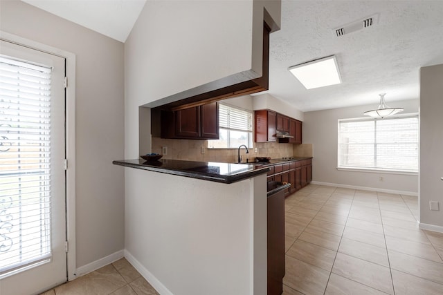 kitchen featuring baseboards, visible vents, decorative backsplash, dark countertops, and light tile patterned flooring