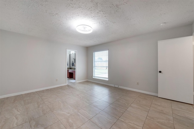 unfurnished room featuring baseboards and a textured ceiling