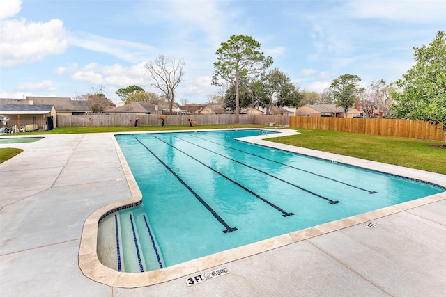 community pool featuring a fenced backyard, an outdoor structure, a lawn, and a patio