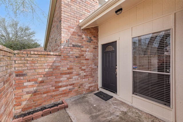 doorway to property with brick siding