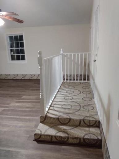 stairs featuring a ceiling fan and wood finished floors