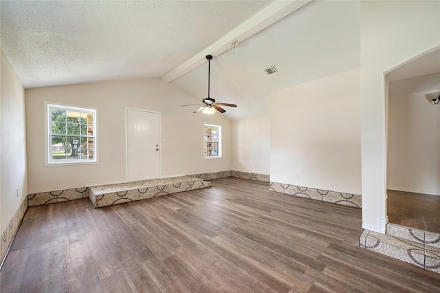 unfurnished living room featuring visible vents, lofted ceiling with beams, a ceiling fan, a textured ceiling, and wood finished floors