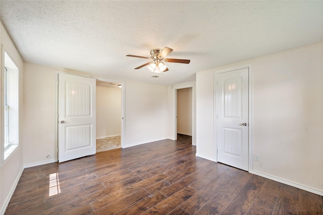 unfurnished bedroom featuring a ceiling fan, a textured ceiling, baseboards, and wood finished floors