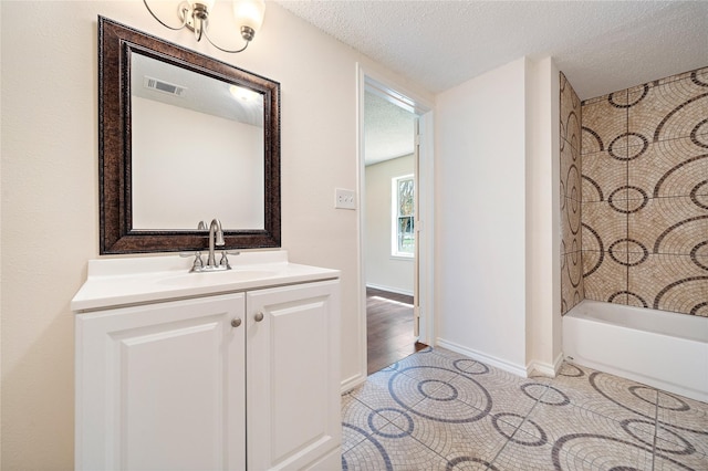 full bathroom with a textured ceiling, visible vents, baseboards, vanity, and tile patterned floors