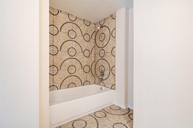 full bath featuring a bathing tub, baseboards, a textured ceiling, and tile patterned floors