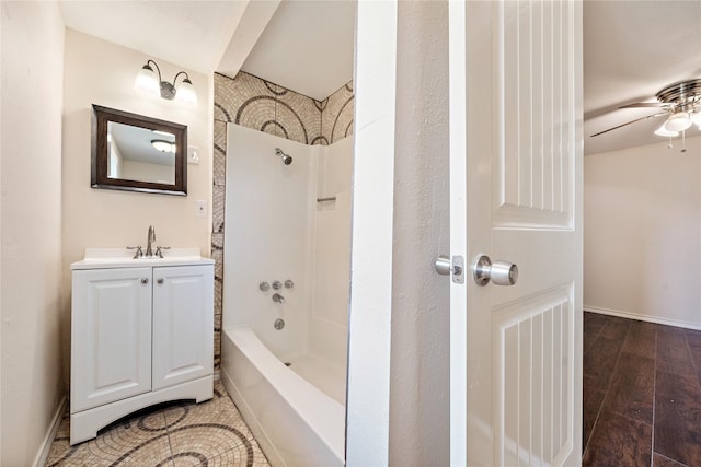 bathroom with baseboards, shower / washtub combination, wood finished floors, and vanity