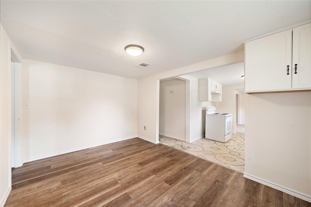 interior space featuring baseboards, visible vents, and light wood finished floors