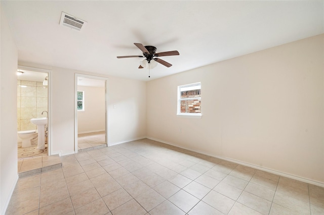 unfurnished room featuring a ceiling fan, visible vents, baseboards, and light tile patterned floors