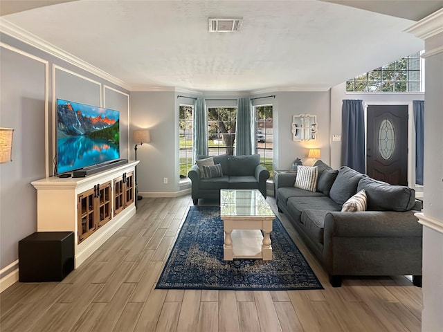 living area featuring ornamental molding, baseboards, visible vents, and wood finish floors