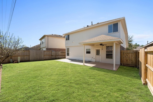 back of house featuring a yard, a fenced backyard, a ceiling fan, and a patio area