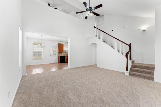 unfurnished living room with light carpet, ceiling fan with notable chandelier, stairway, light tile patterned floors, and a towering ceiling