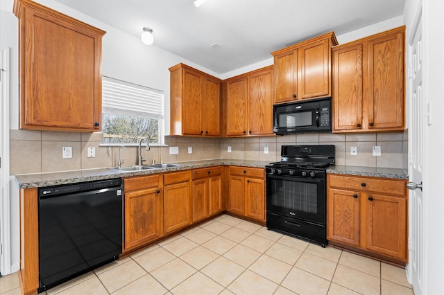 kitchen featuring brown cabinets, black appliances, and a sink