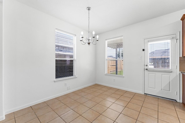 unfurnished dining area featuring a notable chandelier and baseboards