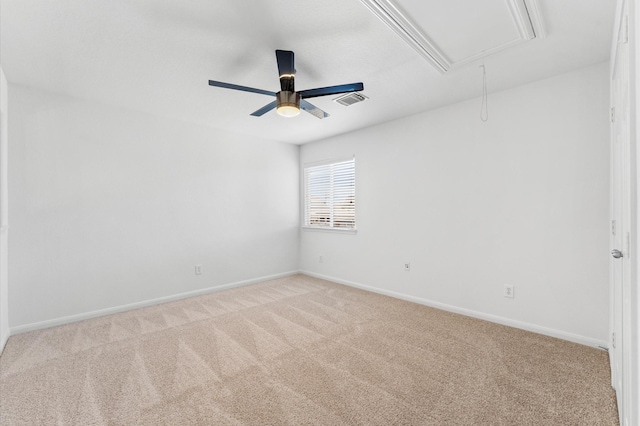 spare room with light carpet, visible vents, attic access, and baseboards