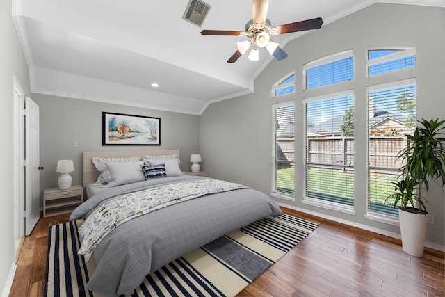 bedroom featuring wood finished floors, visible vents, ceiling fan, vaulted ceiling, and crown molding