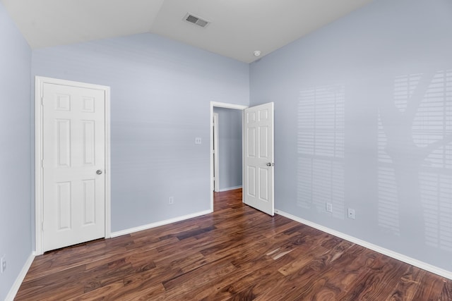 unfurnished room with visible vents, baseboards, dark wood-type flooring, and lofted ceiling