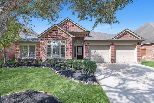 view of front of home with driveway, a front lawn, roof with shingles, an attached garage, and brick siding