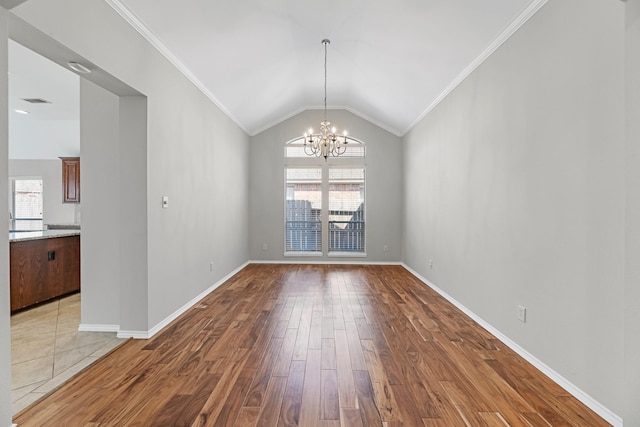 unfurnished dining area with baseboards, lofted ceiling, ornamental molding, wood finished floors, and a notable chandelier