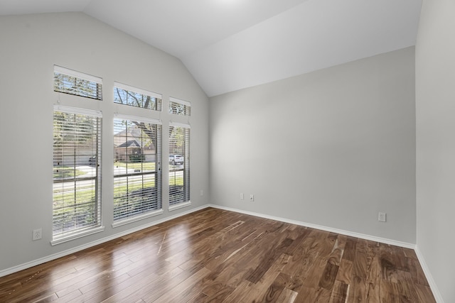 unfurnished room with baseboards, dark wood-style flooring, and vaulted ceiling