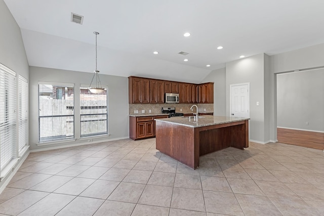 kitchen featuring tasteful backsplash, vaulted ceiling, light tile patterned floors, stainless steel appliances, and a sink