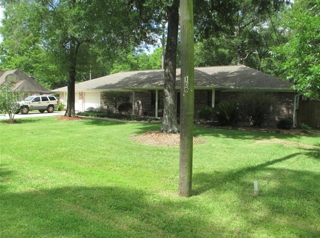 view of yard featuring an attached garage and driveway