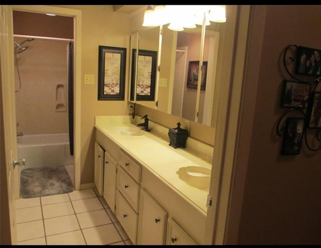 bathroom featuring tile patterned flooring, shower / bath combination, a sink, and double vanity