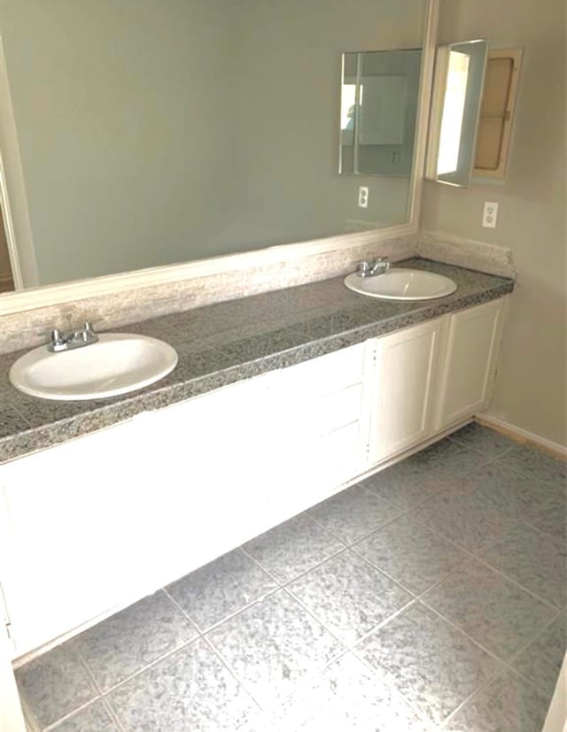 bathroom with double vanity, a sink, and tile patterned floors