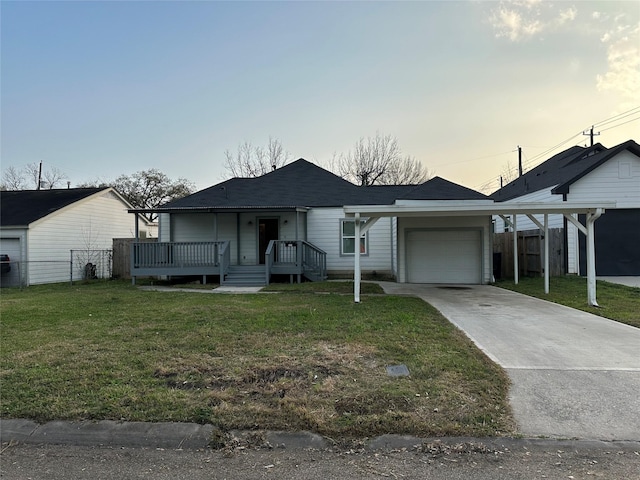 view of front of house with a garage, driveway, a front lawn, and fence