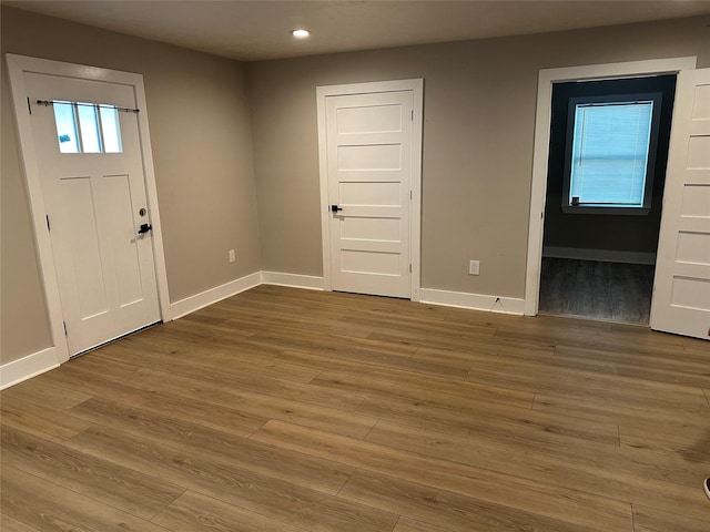 foyer entrance with baseboards, wood finished floors, and recessed lighting