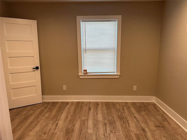 empty room with baseboards and wood finished floors