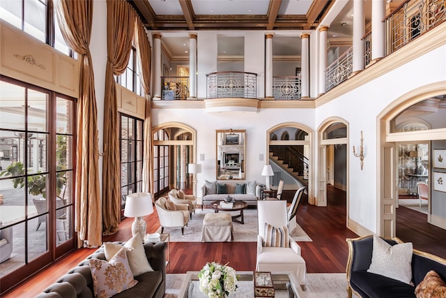 living room featuring crown molding, a high ceiling, wood finished floors, and baseboards