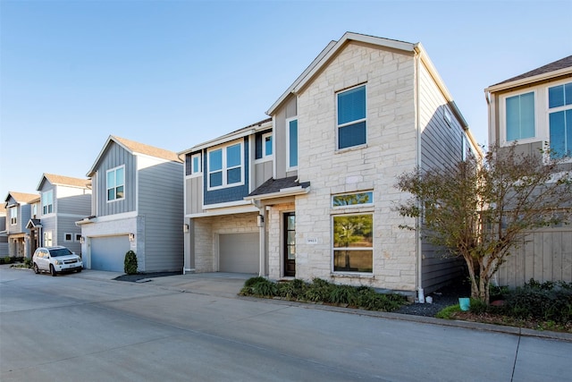 view of front facade featuring a garage, driveway, board and batten siding, and stone siding