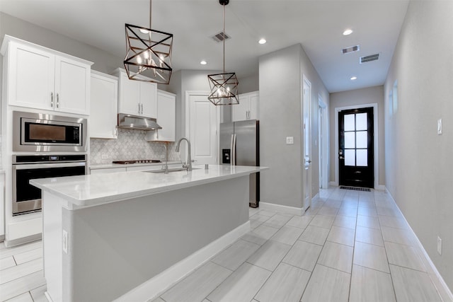 kitchen with under cabinet range hood, visible vents, stainless steel appliances, and a sink