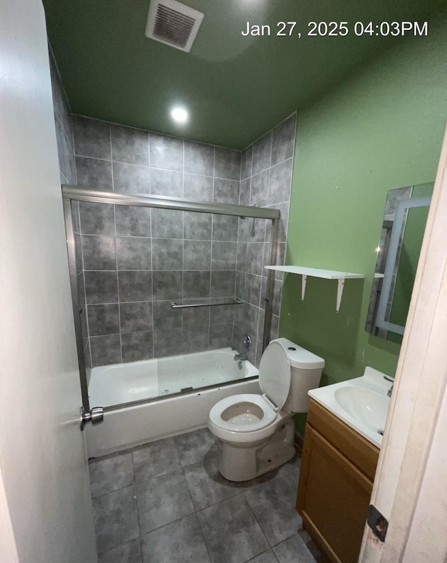 full bathroom featuring toilet, vanity, visible vents, and tile patterned floors