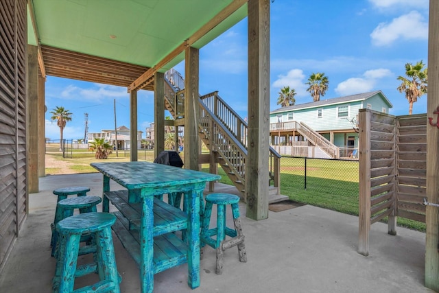 view of patio with stairway, outdoor dining area, and fence