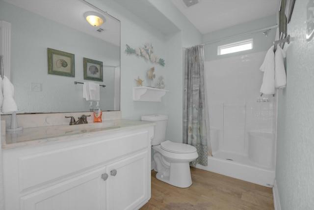 full bathroom featuring visible vents, toilet, curtained shower, wood finished floors, and vanity