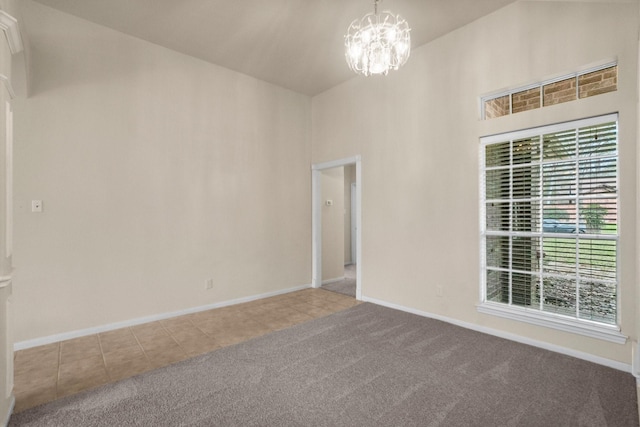 carpeted spare room with tile patterned floors, baseboards, a high ceiling, and an inviting chandelier