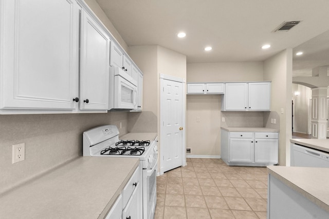 kitchen with visible vents, white appliances, white cabinetry, and light countertops