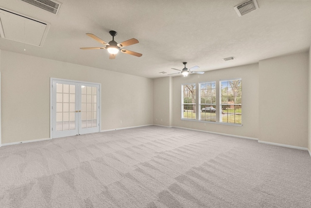 carpeted empty room featuring attic access, baseboards, and visible vents