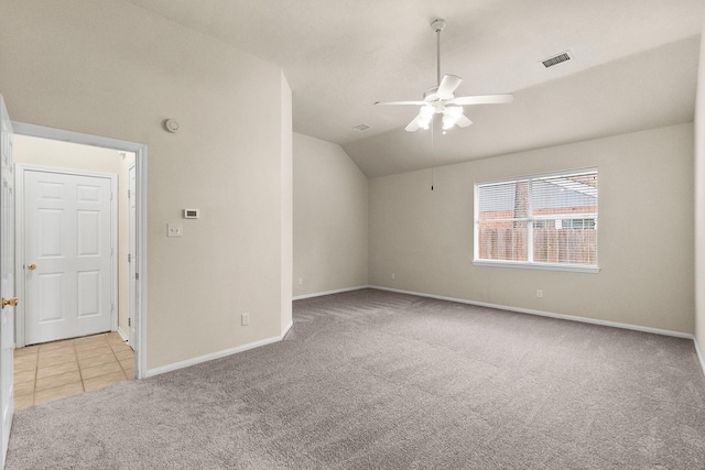 carpeted spare room with baseboards, visible vents, lofted ceiling, ceiling fan, and tile patterned flooring