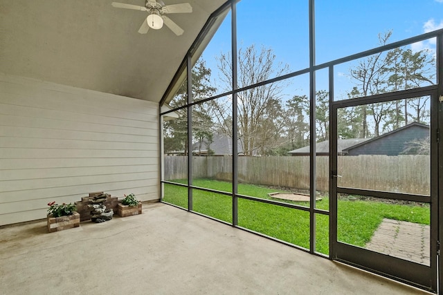 unfurnished sunroom with vaulted ceiling, a wealth of natural light, and ceiling fan