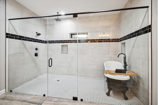 bathroom featuring a freestanding tub and a shower stall