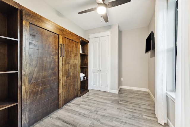 unfurnished bedroom featuring ceiling fan, light wood finished floors, a closet, and baseboards