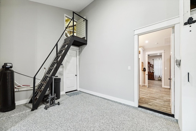 workout area featuring visible vents, a high ceiling, and baseboards