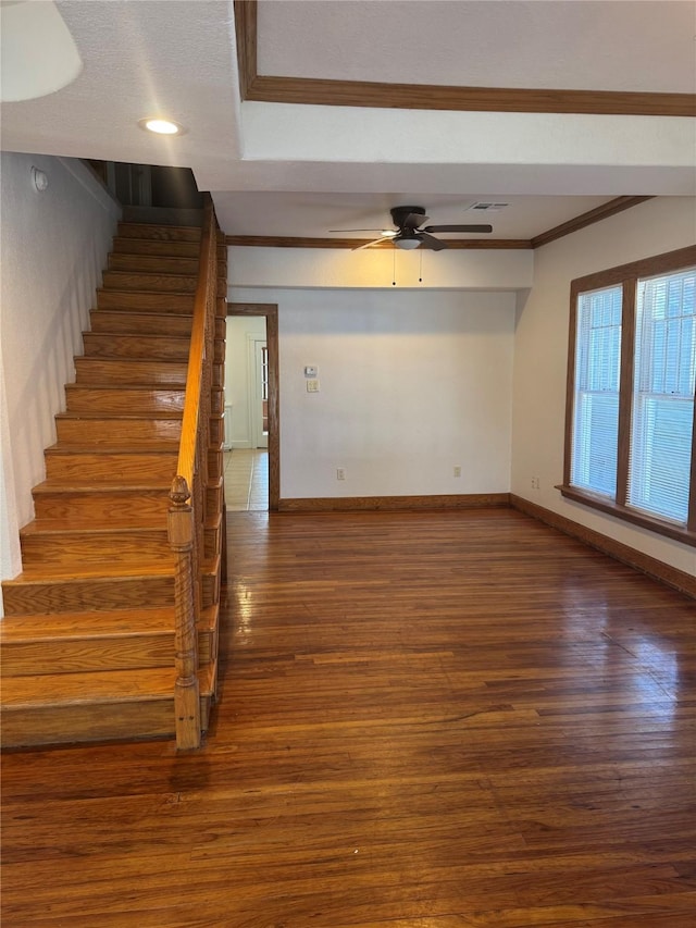 interior space with baseboards, visible vents, ornamental molding, and wood finished floors