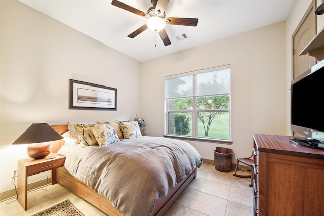 bedroom with a ceiling fan, visible vents, baseboards, and light tile patterned floors