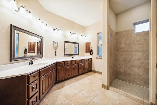 full bath with double vanity, a sink, tile patterned flooring, baseboards, and walk in shower